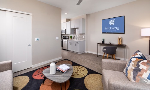 living room with chair coffee table and wall mounted tv
