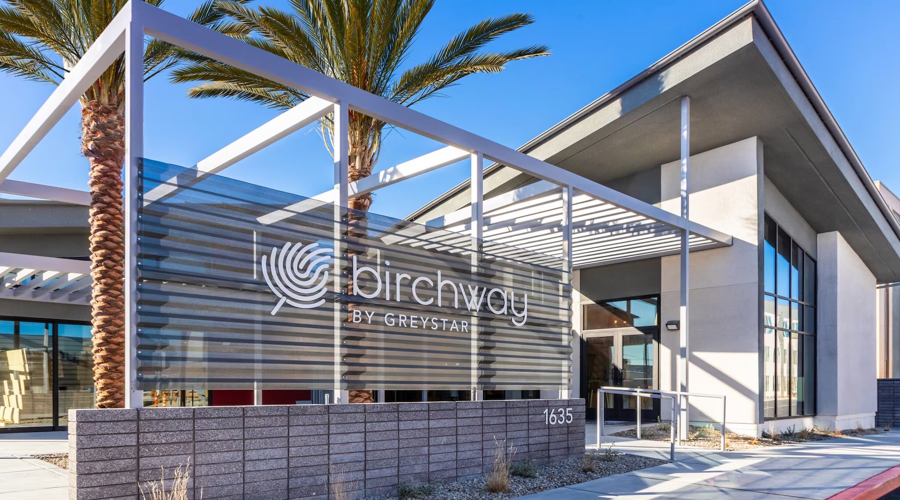 a building with a sign and palm trees
